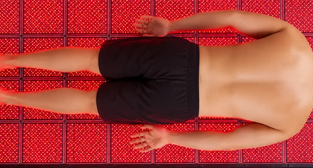 Person using red light therapy to relieve back pain