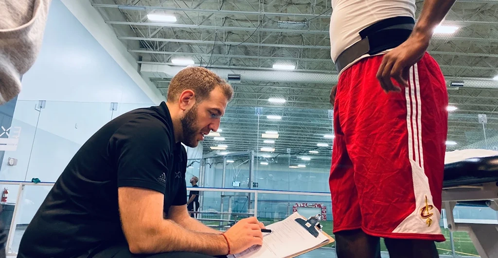Athlete consulting a sports physical therapist for injury prevention and movement assessment before pain develops