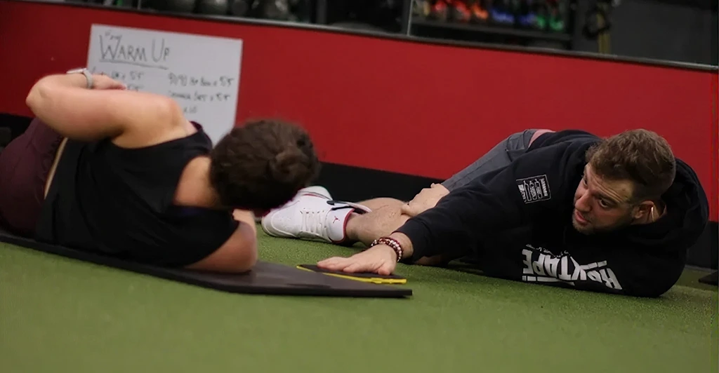 Athlete consulting with a sports physical therapist during a sports PT evaluation for injury assessment and recovery planning