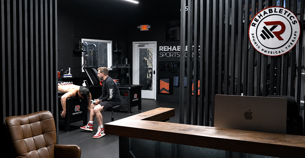 Sports physical therapist helping an athlete recover from a sports injury during rehabilitation at a South Jersey physical therapy clinic