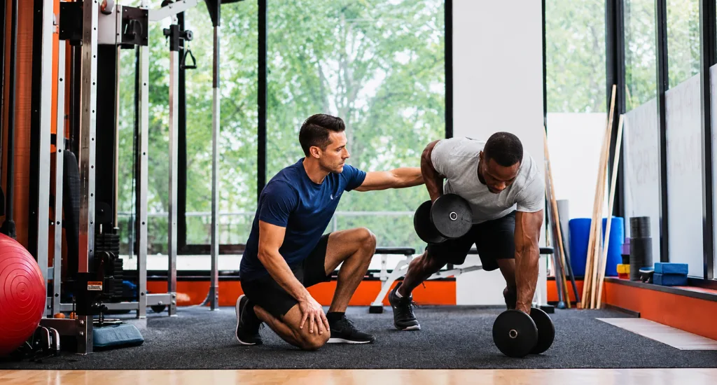 Personal trainer guiding a client through strength training