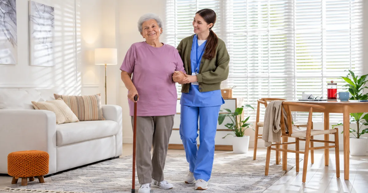 Older adult walking with a cane during knee replacement recovery