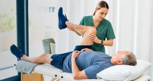 Physical therapist guiding a patient through knee replacement recovery exercises