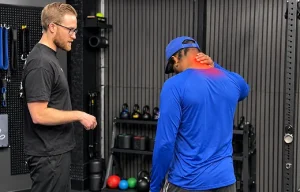Therapist using hands on manual therapy along a patient's neck and upper shoulders during treatment