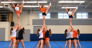 Cheerleading stunt group lifting a flyer on a spring floor