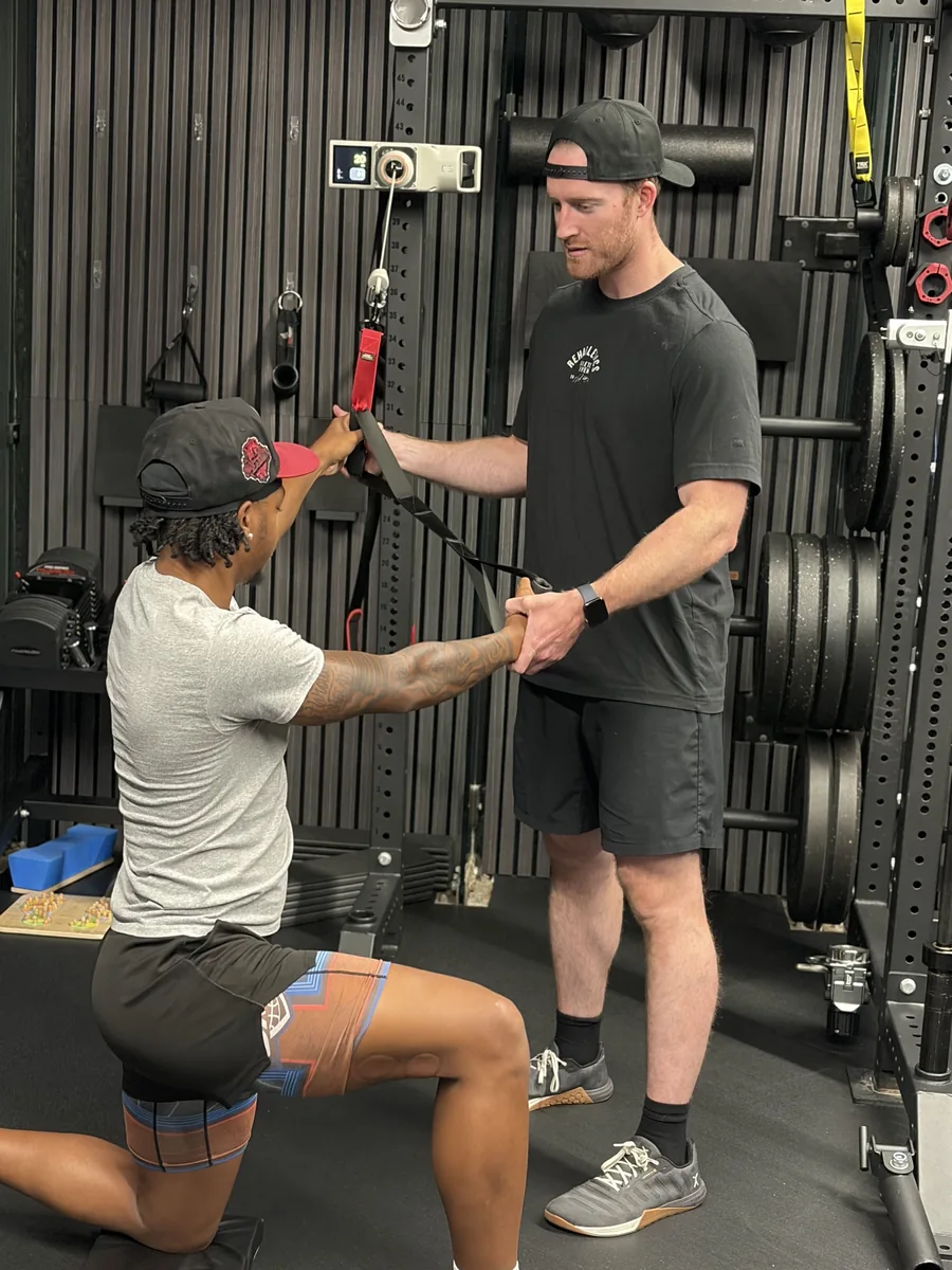 Dr. Erik Bonn guiding an athlete through a shoulder stability exercise