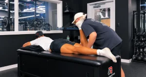 Sports physical therapist assessing an athlete's knee after a torn ACL and meniscus